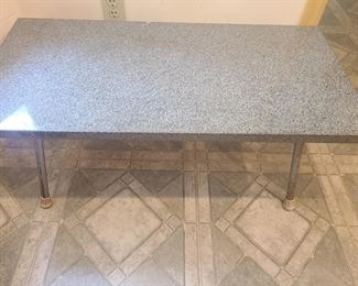 Granite table top with metal legs. Table top is in great condition. Table isn’t very large but is very heavy. Measures 38" x 18" x 14". Please bring help to move, it is heavy. This table was custom built in Elberton, GA by a family member of our client's mother and has been in the family for years.  https://ctbids.com/#!/description/share/953501