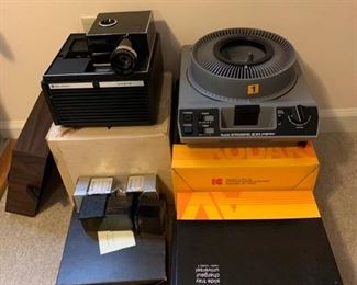 These are two vintage slide projectors made by Kodak and Bell & Howell. There is a circular slide projector and slide trays and a cube slide projector with some cube slides. https://ctbids.com/#!/description/share/953390
