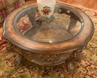 #24	round glass top table with carved sides and legs 40.5x20	 $125.00 
