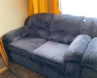 Two-cushioned dark blue sofa, part of living room furniture set.