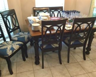 Dining table (with leaf) with stained wood top and chunky black legs and apron; 6 matching chairs with pretty upholstered seats