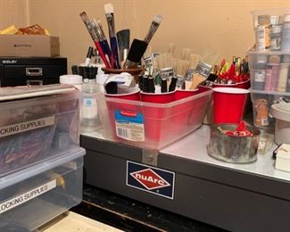 Flocking supplies, tabletop filing cabinet, boxes of colored artist paint, professional and craft paintbrushes, sharpie markers, vintage nuArc giant portable light table
