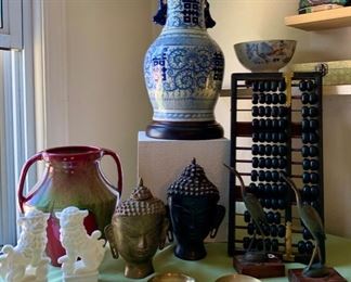 Stunning blue and white porcelain Asian design table lamp, two handled Weller pottery jug, white porcelain foo dog statues, vintage brass trinket dish, vintage black wood abacus, vintage Tibet Buddha Shakyamuni head statues