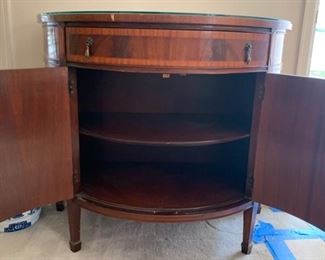 Beautiful antique/vintage demilune half moon cabinet with custom glass top. In great condition with one knick on trim and some wear/scratches on feet. Measures 38" wide, 19.5" deep and 33" tall. 