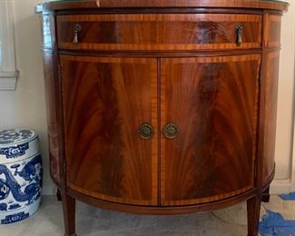 Beautiful antique/vintage demilune half moon cabinet with custom glass top. In great condition with one knick on trim and some wear/scratches on feet. Measures 38" wide, 19.5" deep and 33" tall. 