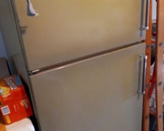 Green refrigerator with top freezer.  Used as spare refrigerator in garage.   Food items not included.