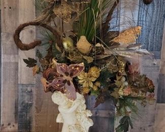 Dramatic Faux Flowers in Bisque Cupid Vase.               Has the effect of the Cupid offering you flowers would adorn the most lavish entry
15in to top of  vase and 37in to top of flowers 