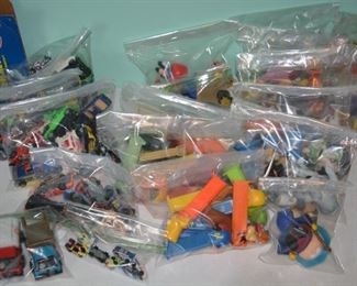 various bags of diecast, pez, toys, balls, and more