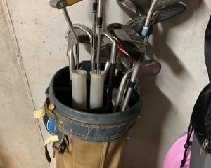 Golf clubs in two men's bags include Taylormade Original One, Calloway Big Bertha & Great Big Bertha,  Ping Eye 2, etc.