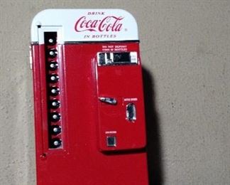 7 inch  tall by 3 3/4 inch wide Mini Coca Cola Machine, in great good condition.  Push button on back to open and see details in side.  No box