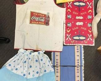 Seven pieces of fun vintage linen aprons, hot pads, towels, mats