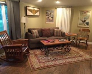 Sofa hide-a-bed, craftsman style rocking chair, arts and crafts style coffee table, oak mid century chair, World War II posters. The mosaic walk hanging is not included in this sale.