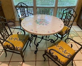Heavy iron table with tile top and 4 iron chairs