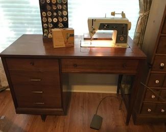 Sewing cabinet with antique Singer machine. Additionally, there are several bins of sewing supplies.