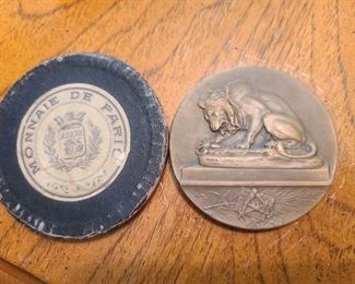 This is photo of velvet holder and back of coin has lion* sculpture made by Barye