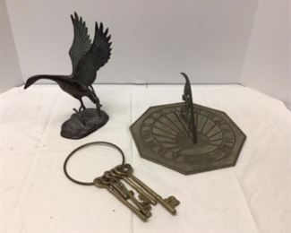 metal bird sculpture , sundial, keys