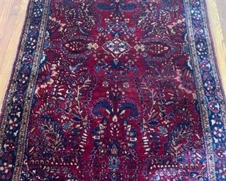 Antique Rug with orange size hole in upper right area of rug.