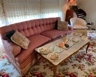 Vintage pink curved sofa with fringe, marble top coffee table