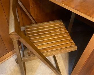 Drop leaf table on castors with 4 folding chairs that tuck away underneath