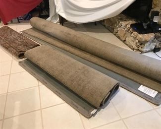 Back row: Calvin Klein area rug, 10' x 10' , $450; front right: Calvin Klein area rug, 5'3" x 7'5", $250; front left, multi color area rug, 8' x 5'5", $110.