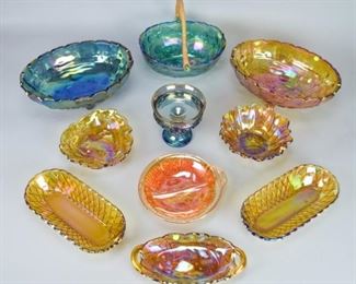 38	Carnival Glass Grouping	10 pieces of carnival glass. All unsigned, including Indiana Glass Loganberry pattern bon bon, approximately 7 1/2"-diameter; Indiana Glass King's Crown pattern compote, 5 1/4"H; 2 Indiana Glass Harvest Grape pattern oval footed bowls, each 12 1/4"L x 4 1/2"H. Roughness on rim of 2 handled dish, small chip on underside of handle on round amber dish, chips and roughness on rim of amber Harvest Grape bowl, roughness on rim of 1 of pair of oval dishes.
