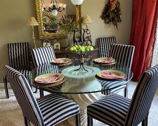 Contemporary glass top dining table with 6 upholstered chairs.