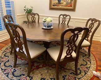 Round dining room table 78" diameter with 6 upholstered chairs.