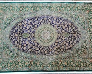 Signed silk Persian carpets, one of two in the sale.