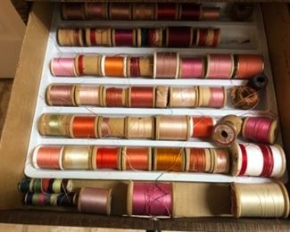 Several trays of thread on wooden spools