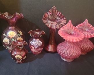 Set of three Fenton hand painted reddish/pink vases with beautiful flowers and one that is plain. Largest one measures 5" x 9". Boy fishing on vase done with white paint measures 4" x 6". There is also a pair of Fenton hobnail vases in a lighter shade of red. https://ctbids.com/#!/description/share/974608