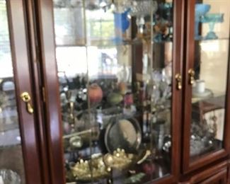 China cabinet with glassware and collectibles.