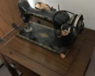 Singer sewing machine in cabinet.