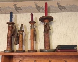 Large wood bobbins have new lives as candleholders alongside a set of wooden books. 
