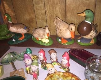 The seven dwarves look for Snow White while a family of ducks watch. 