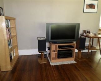 Olevio TV with speakers on stands, Yamaha blueray player, Yamaha stereo receiver, Yamaha CD player, cabinet, antique claw-foot table.