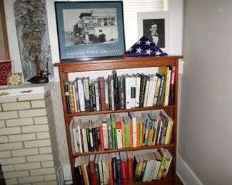 Mission-style bookcase; many books; "Brains $.25" poster; redwood poster; duck doorstop; memorial flag; New Mexico tiles.