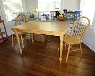 Wooden dining table with two chairs.