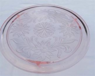 Lot Number:	261
Lead:	Pink Depression Cake Plate
Description:	daisy design; 3 footed 10" diameter