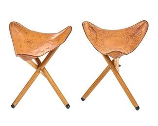 Host tripod stools, unmatched pair (Denver, Colorado), having hand finished torn leather saddle-style top featuring Western and bull embossed motif, rising on wooden tripodal base