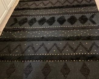 Black rug with embellishments.