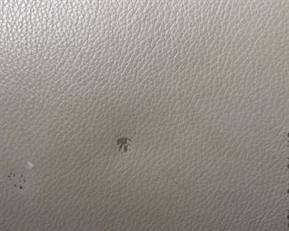 detail of scuff on left arm of leather sofa