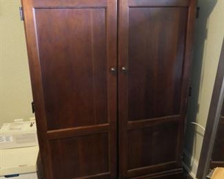 Small scale computer work center armoire with double doors.