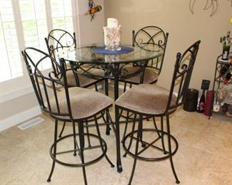Kitchen informal dining with glass top table and four tall chairs