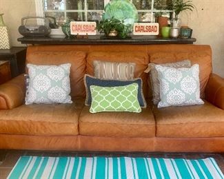 Distressed leather sofa: pillows, and outdoor items 
