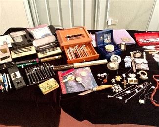 Jewelry table full of interesting things incldin* Craftsman tools and high end writing pens.