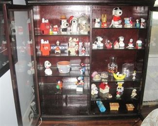 Vintage cabinet with glass doors and Snoopy collectibles.