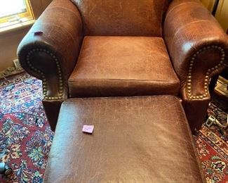 Leather upholstered armchair and ottoman