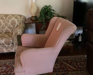 The matching pink rocker, a very old drop leaf table, a mid century lamp, iconic wall decor, large flat screen TV