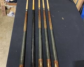 Four nice pool cues and bridge