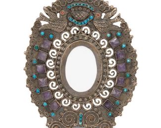 32
A Matl-Style Sterling Silver Picture Frame
1978 or later; Mexico City, Mexico
Marked: MR-39 / Mexico / 925
The oval sterling silver picture frame with dove motif and set with amethysts, turquoise, and coral
Frame: 5.25" H x 4.125" W x 2.5" D; Opening: 2" H x 1.5" W
126 grams
Estimate: $300 - $500
